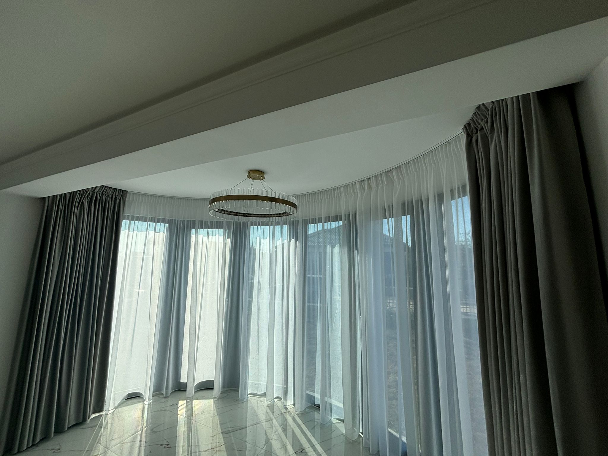 Perdele și draperii cu șină curbată pentru living – elegant și practic – Decora Design București